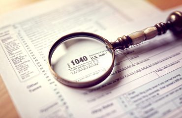 Income tax 1040 us individual tax return form and magnifying glass
